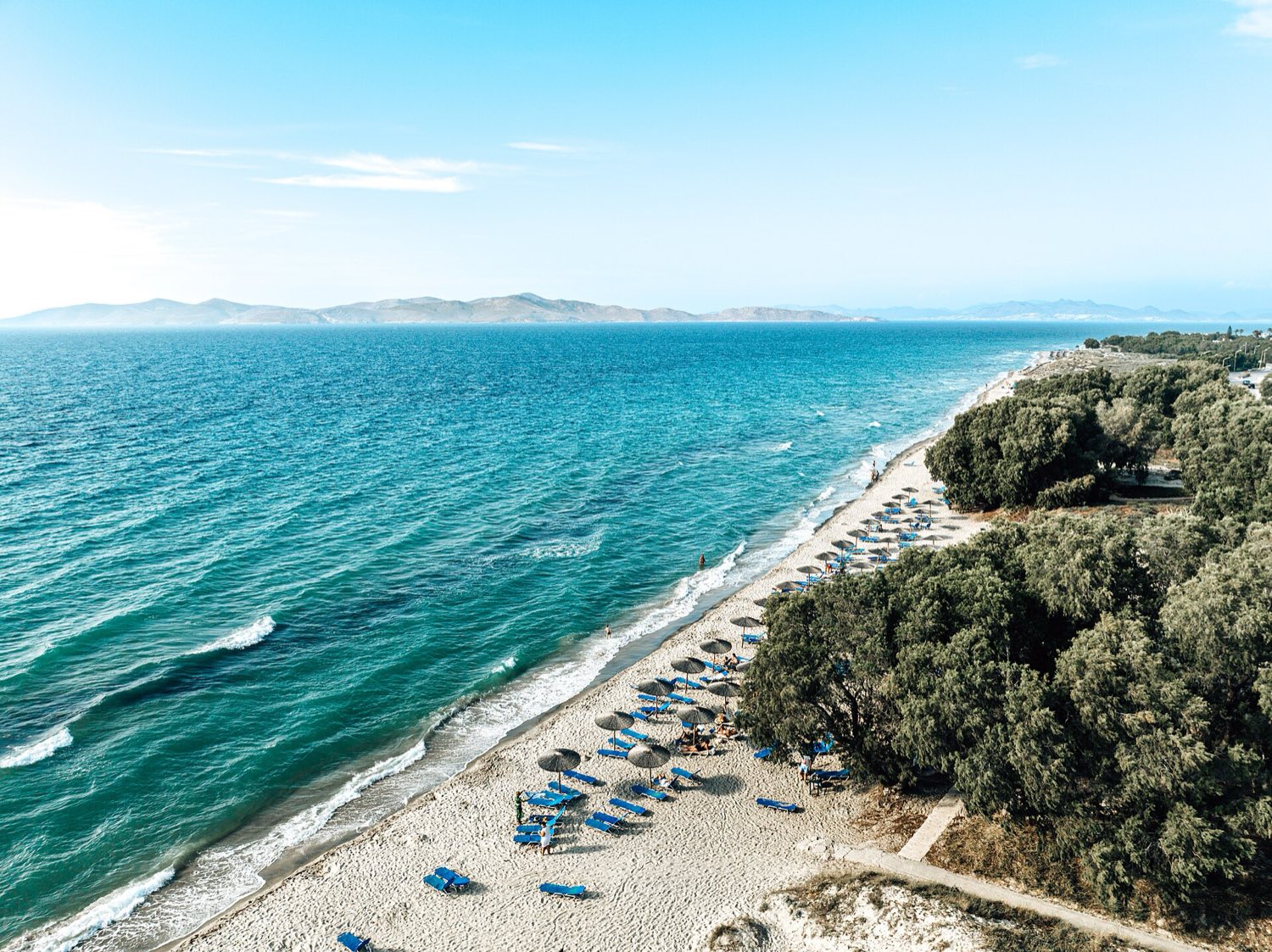 Children playing in shallow water on a sandy family beach on the north coast of Kos
