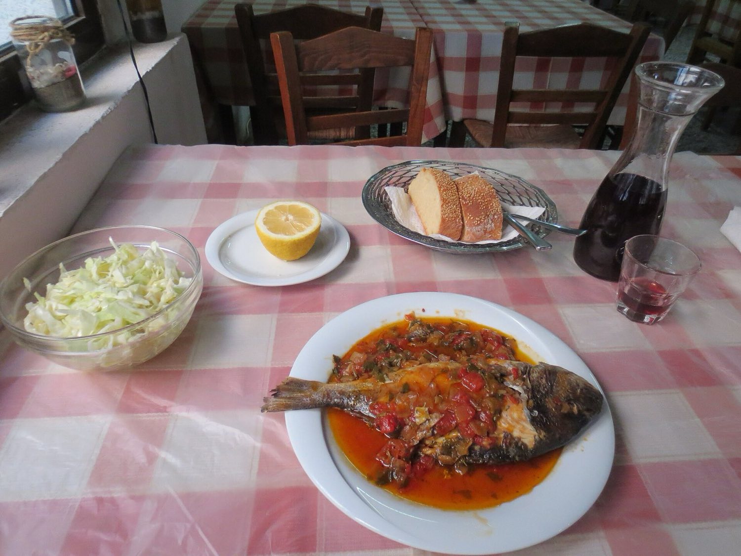 Taverna table with grilled fish, salad and bread, a typical Kos meal