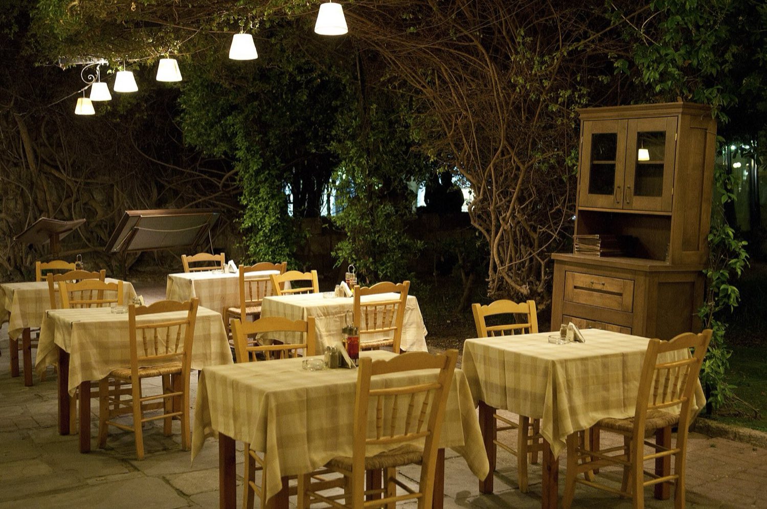 Illuminated bar terraces and crowds on a pedestrian nightlife street in Kos Town after dark