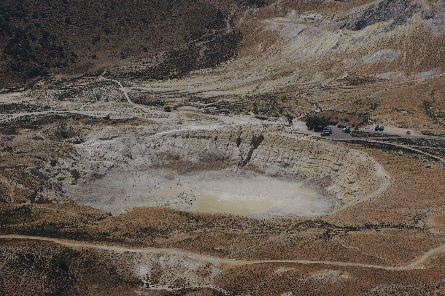Bare rock and sparse vegetation beside the Stefanos crater on the Nisyros volcano near Kos