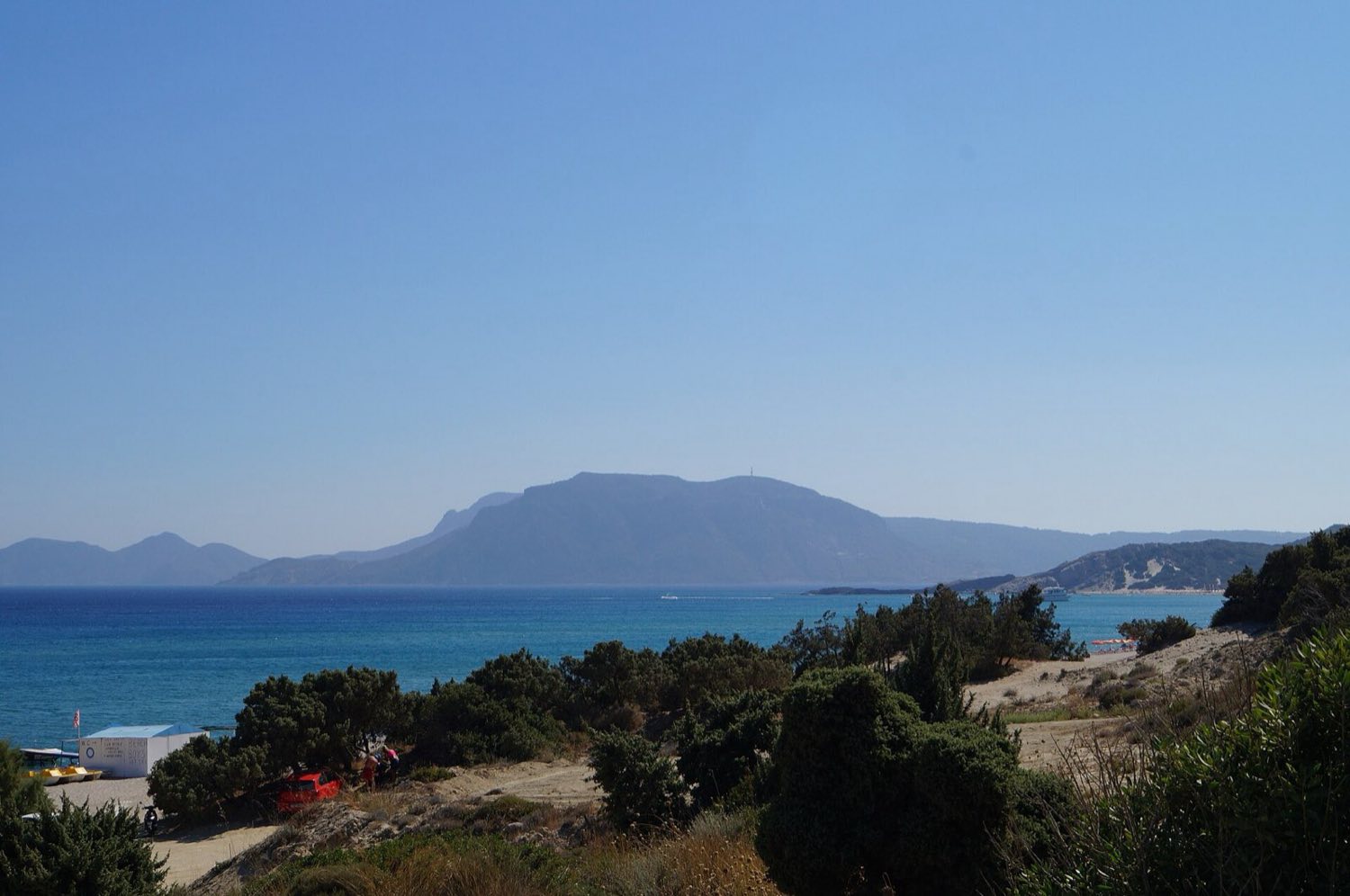 Fine golden sand and shallow turquoise water at Paradise Beach in Kefalos Bay, Kos