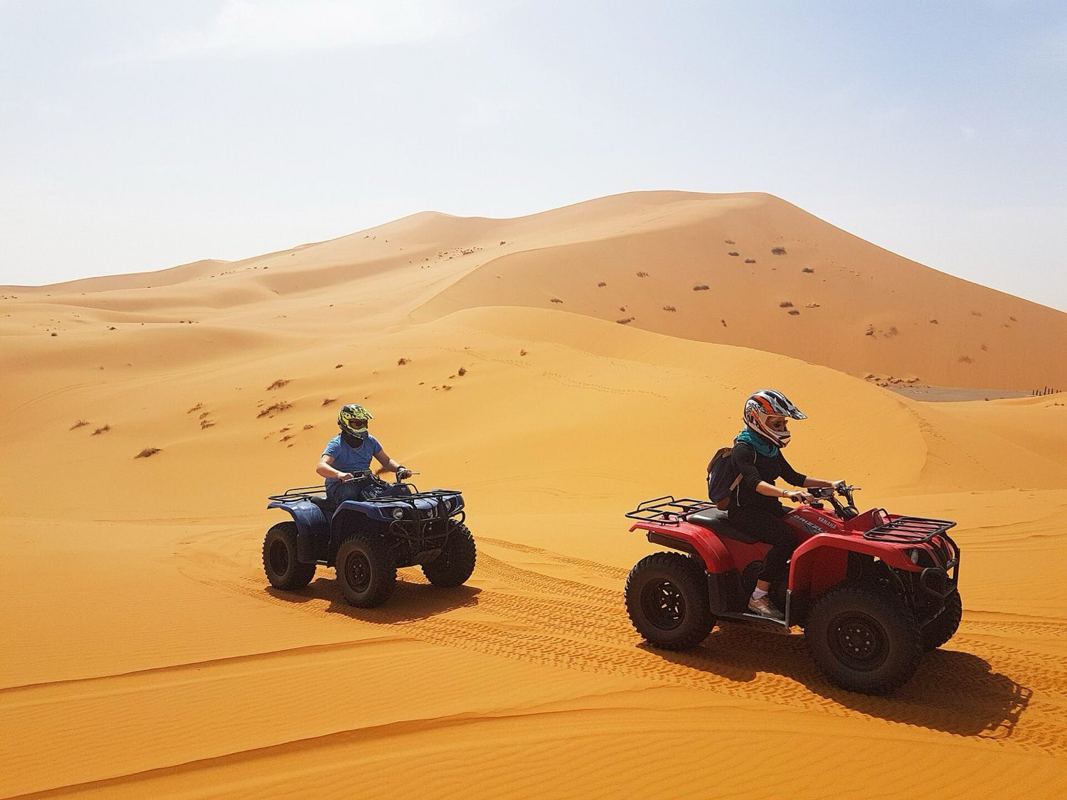 Quad bikes lined up on a dry dirt track at the start of an off-road tour
