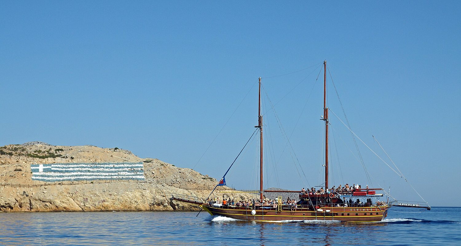 Excursion boat anchored in a turquoise bay on the Kos 3-island cruise route